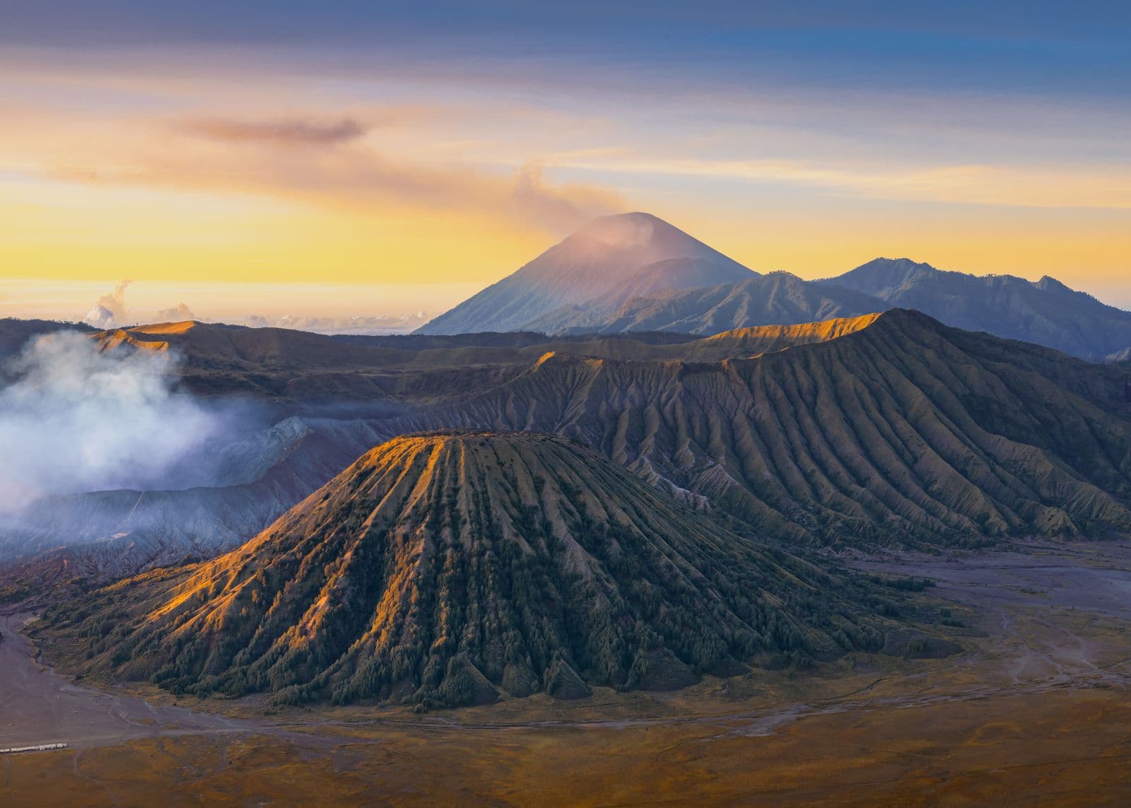 Mount Bromo's caldera at sunrise with mist across the sea of sand, Java