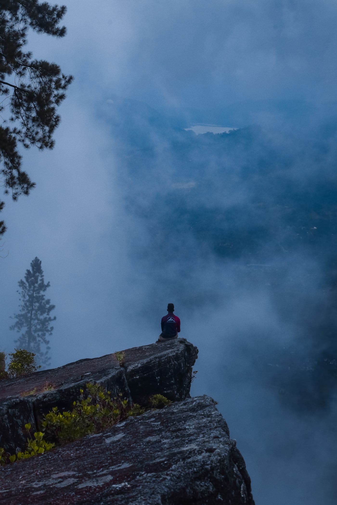 A lone traveller on a misty clifftop in the Sri Lankan hill country