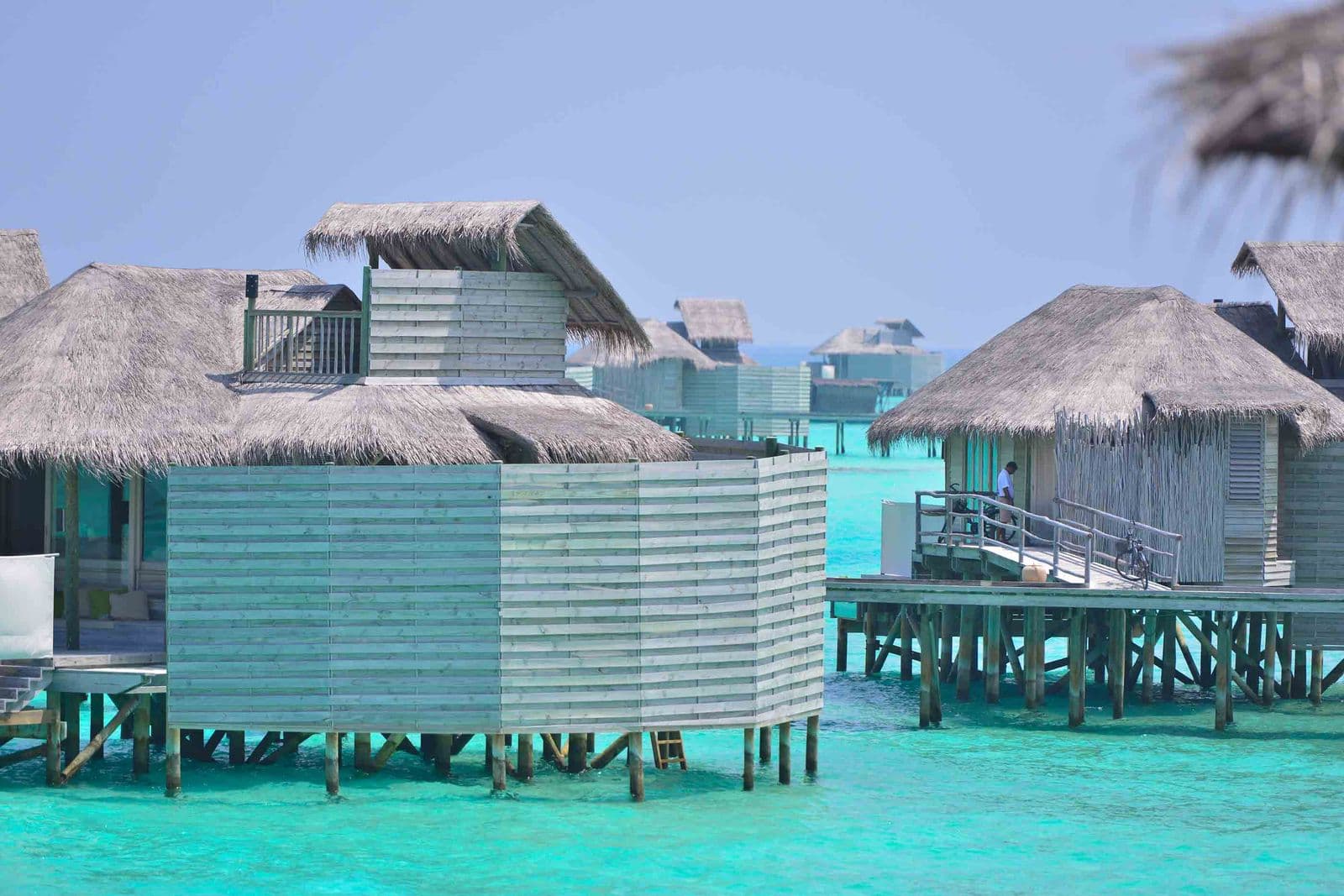 Overwater villas on stilts above a turquoise Maldivian lagoon